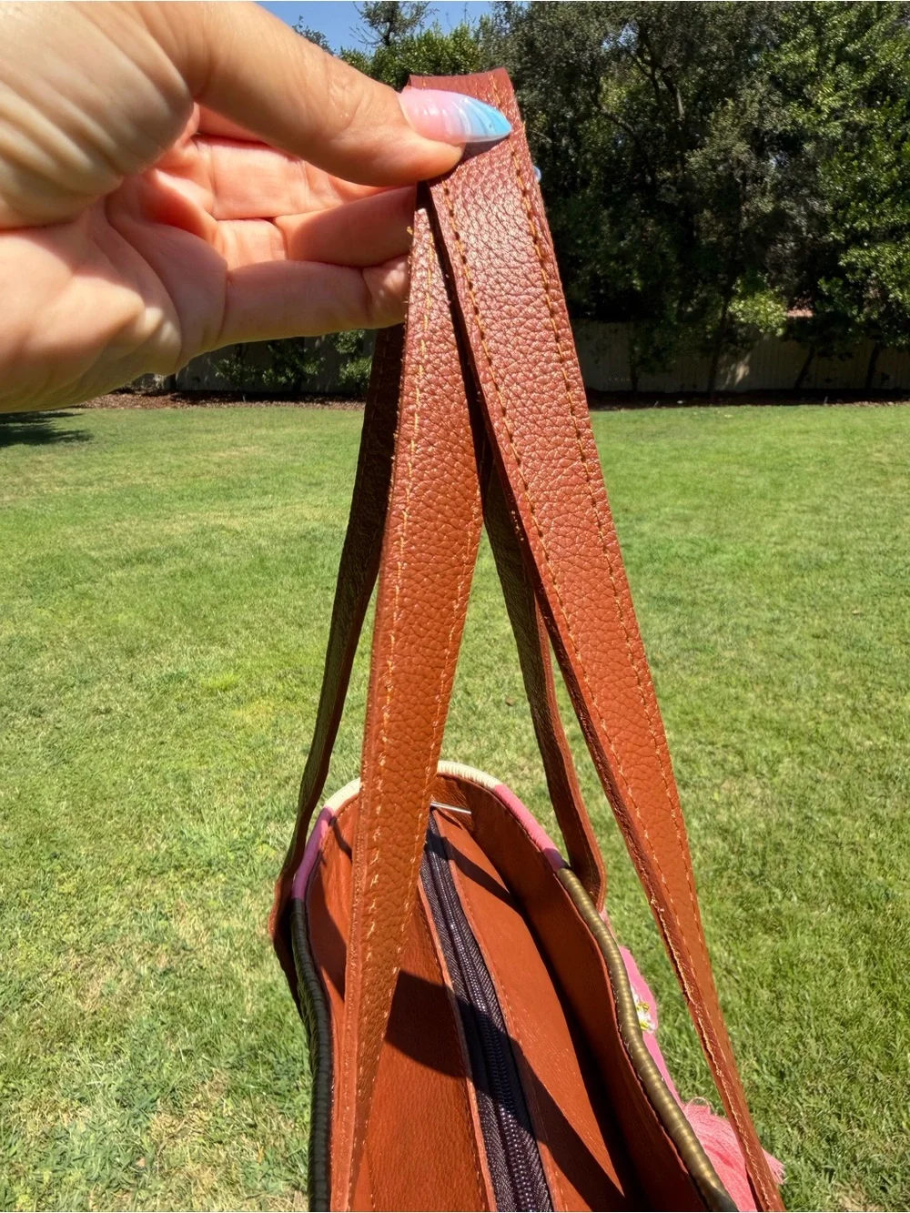 Woven Straw Tote Bag with Brown Leather Handles and Pink Tassel Accent